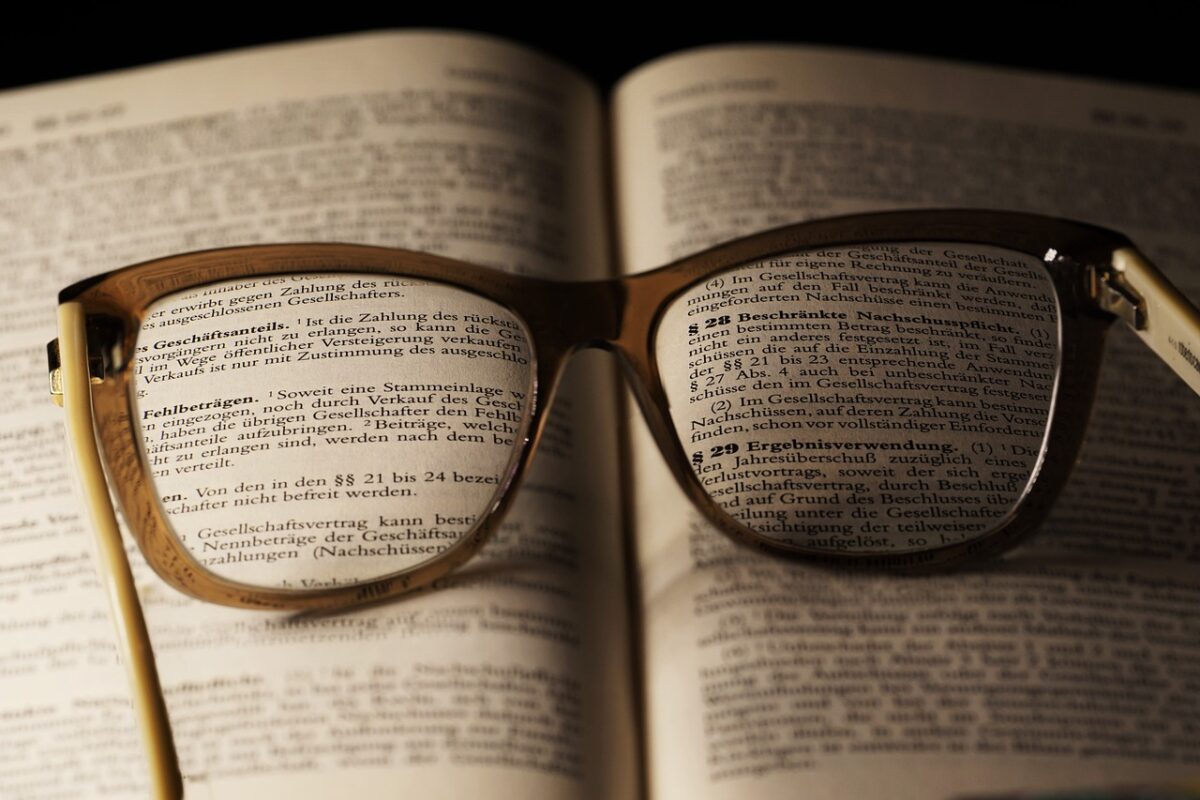 A pair of glasses sitting on top of an open book.